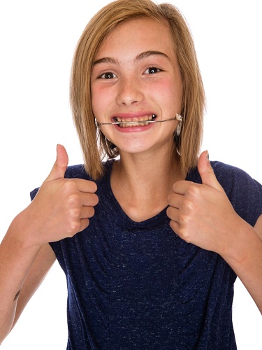 girl smiling headgear thumbs up