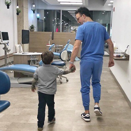 Dr. Justin holding hands with young child