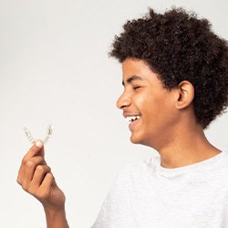 Teen smiles at his clear aligner