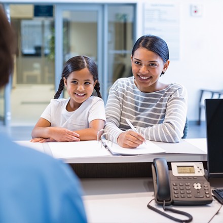 Mom and daughter checking in at dental office