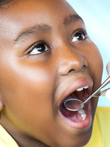 child being checked by a dentist