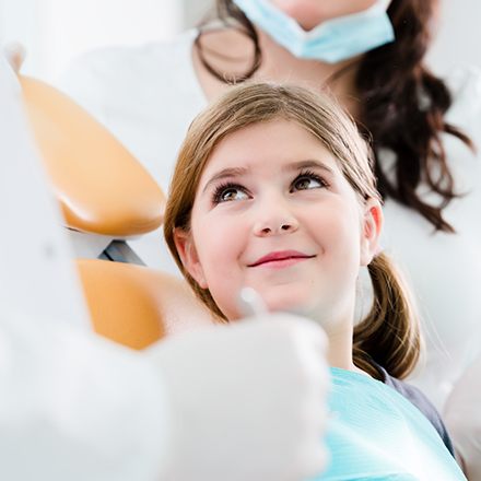 Smiling young girl in dental chair