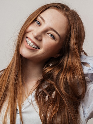 A young girl with braces smiling.