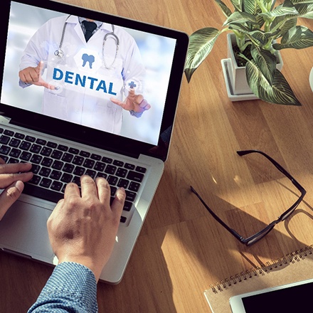 a person researching their dental insurance benefits on a laptop