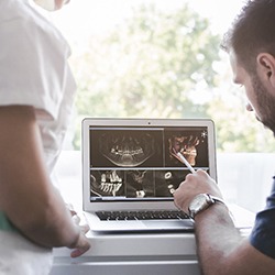 two orthodontists examining X-rays on a laptop