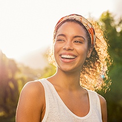 a person standing in a park and smiling 