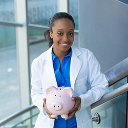 a dentist holding a piggy bank