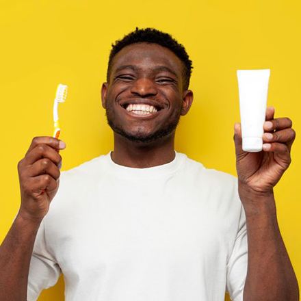 Happy man holding toothbrush and toothpaste