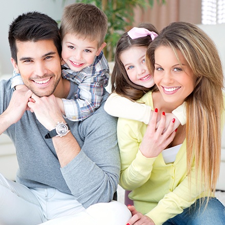 Mother father and two kids smiling together