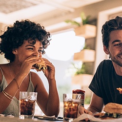 Friends smiling while eating at restaurant