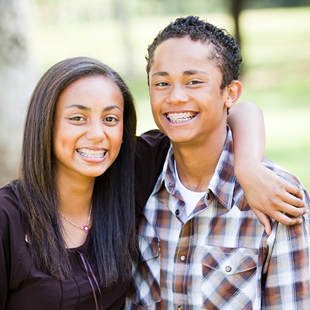 Young man and woman smiling outside