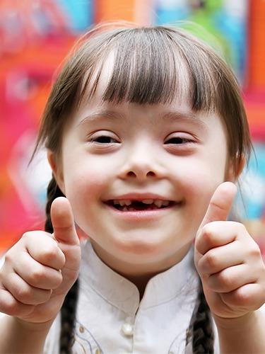 Smiling little girl giving thumbs up