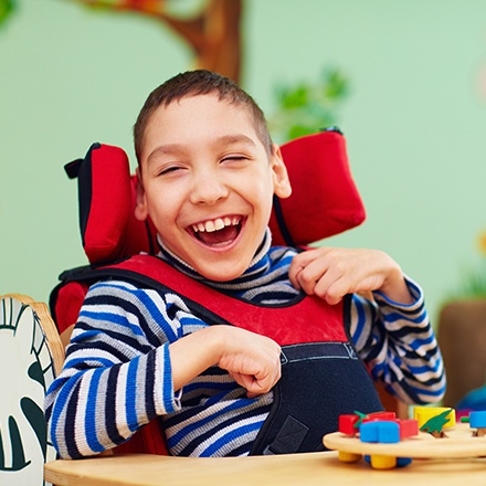 Laughing young boy in wheelchair
