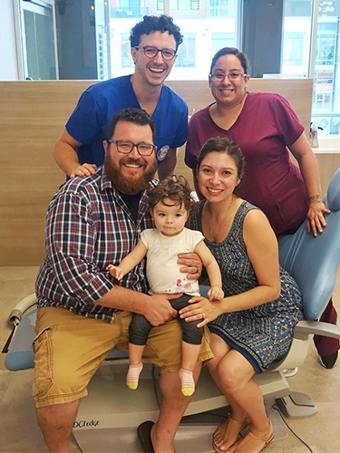 Smiling family in dental office with Dr. Justin