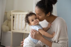 mom kissing baby recovering from a lip and tongue tie