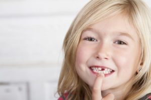 little girl visiting the dentist to take advantage of children’s dental insurance coverage