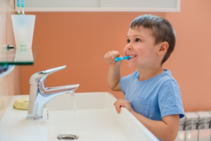a young child brushing his teeth 